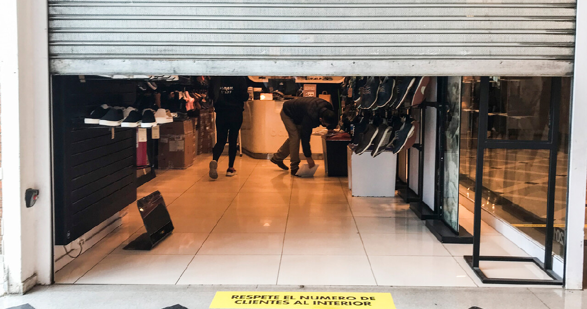 Un local de zapatillas bajando su cortina metálica