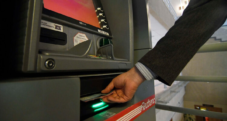 Hombre sacando billetes de un cajero