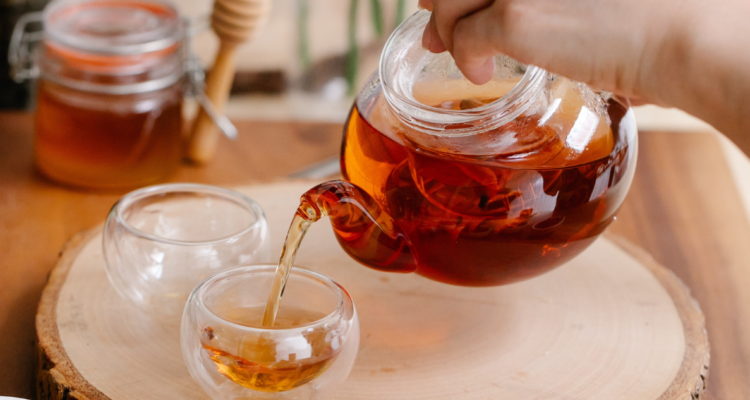 Desmitificando la sobremesa: Por qué tomar té o café después de las comidas podría ser perjudicial Esta antigua práctica es un momento de socialización entre los comensales, quienes se quedan sentados a la mesa por un periodo que puede extenderse desde media a una hora, o incluso más. Dependiendo de la zona geográfica, en la sobremesa suele servirse té, café o algún bajativo. Este margen de tiempo se toma ya que, previo al almuerzo, comienza el proceso digestivo; momento en el que se deben evitar esfuerzos físicos y donde la personas aprovechan de conversar y compartir. La especialista en nutrición oncológica y deportiva, Gabriela Saez Escobar, explica que esta práctica tan masificada en nuestro país (e incluso alrededor del mundo) debe evitarse pues interviene, negativamente, en la absorción de nutrientes importantes como el hierro o fierro; elemento muy presente en las carnes rojas tan consumidas durante esta temporada. ¿Cómo el té o el café alteran el proceso digestivo? La nutricionista explica que el té y el café poseen taninos; ciertas sustancias orgánicas que también pueden definirse como polifenoles (sustancias químicas encontradas en plantas con gran poder antioxidante). Para explicar el fenómeno nutricional, la profesional ocupa también el término biodisponibilidad: el grado y velocidad con la que una materia accede a la circulación y llega, posteriormente, a su lugar de acción e influencia. “Los taninos; polifenoles presentes en el café y té, reducen la biodisponibilidad de hierro debido a la formación de complejos insolubles que no pueden ser absorbidos. El hierro se encuentra presente en carnes, mariscos, aves y algunas legumbres, alimentos característicos de una comida o almuerzo”, explica la diplomada. Puede pensarse, entonces, que quizás esta costumbre de la sobremesa afecta solamente (o en mayor medida) a aquellas personas propensas a un déficit de fierro, tales como pacientes con anemia, ya que acentúa la disminución del elemento en el sistema y, por ende, agrava la enfermedad. Gabriela refuta esta idea. “(Esta práctica) afecta a todas las personas que realicen la dinámica: almorzar o comer y posteriormente consumir té o café”, comenta. En el caso específico de una persona que sufra anemia por deficiencia de hierro, debe existir tratamiento médico, continúa. “(Hay que) realizar la suplementación respectiva y evitar esta práctica para poder revertir el cuadro”, explica la dietista. ¿Anular la sobremesa u optar por otras infusiones? Esta explicación científica de por qué es negativo beber té o café luego de comer no significa, en lo absoluto, que deba eliminarse la sobremesa. Más bien, pueden considerarse una serie de alternativas para seguir practicando esta antigua y tradicional costumbre de quedarse sentado en el comedor después de almuerzo. Hay varias opciones. Si bien hay personas que sólo beben té o café después de la comida, la profesional recomienda el reemplazo de estas bebidas calientes por otras infusiones que sí ayudan en el proceso digestivo. “Puede consumirse una bebida caliente tipo infusión, ya sea simple, con alguna rodaja de limón, plantas naturales como el hinojo, jengibre, anís, manzanilla, menta, poleo o boldo”, sugiere Gabriela Saez. Otra alternativa, en palabras de la profesional, es esperar que pasen al menos dos horas después de comer para tomar un té o café, para así no interferir en la correcta absorción de los micronutrientes. La necesidad de una alimentación equilibrada En el caso puntual de aquellas personas que ya cuentan con problemas base de carácter digestivo (tales como malabsorción de nutrientes, déficit de hierro, desnutrición, entre otros), es recomendable acompañar los alimentos ricos en hierro previamente nombrados con algún comestible alto en vitamina C: frutas cítricas, pimientos, tomate, verduras como el brócoli, papas, etc. Si se realiza lo anteriormente mencionado, con mayor razón debe evitarse la ingesta de té o café luego de comer, pues con estos bebestibles, el esfuerzo tomado al complementar el plato rico en fierro con vitamina C, sería en vano. ¿Esperar dos horas o servirse un agua de menta? Gabriela apunta a que la sobremesa es totalmente compatible con hábitos de cuidado como llevar una alimentación sana y completa. Sólo es necesario tomar los resguardos necesarios: esperar a que el proceso digestivo termine antes de beber un té o café (en el caso de no querer reemplazarlos), o preferir infusiones digestivas como aquellas nombradas anteriormente. La sobremesa es una práctica cultural rica y muy común de nuestro país. Mientras se esperan las dos horas posteriores a la comida se puede recurrir a otro hábito frecuente del almuerzo: la siesta (en especial estas Fiestas Patrias cuando los platos de comida son considerablemente contundentes). De esta manera, al salir de los brazos de Morfeo, será el momento idóneo para compartir con amigos y/o familiares una taza de té con galletas, o en este tiempo, con algún rico dulce dieciochero. Así, se podrá disfrutar de una segunda patita de comida libre de problemas de absorción de nutrientes.