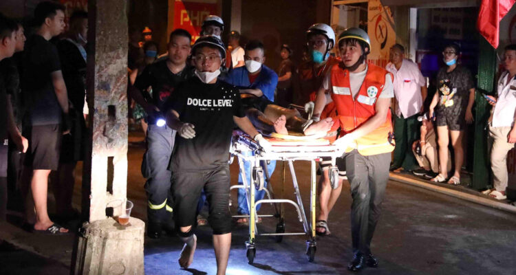 Rescatistas asisten a una de las víctimas del edificio en Hanói