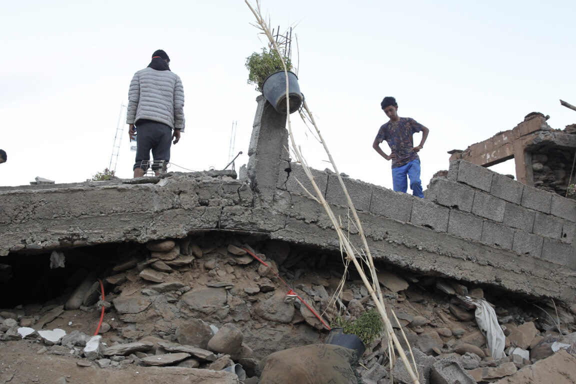 Abdelkabir (i) y Nabir, sobre la casa destruida en la que murieron su padre y su hermana tras el terremoto