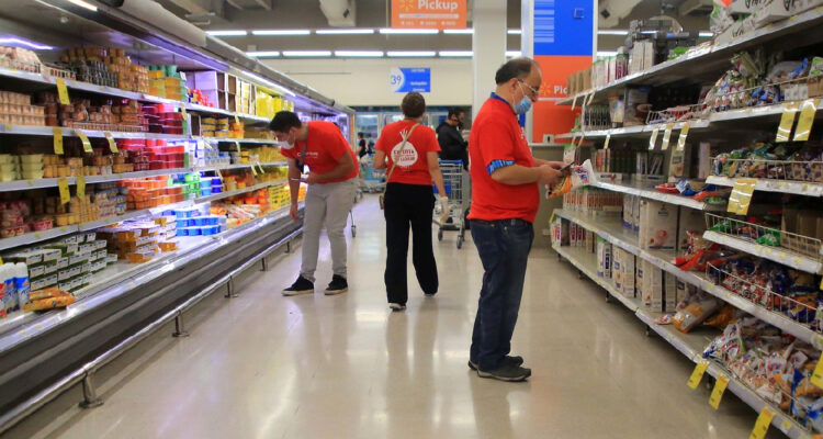 Personal de aplicaciones comprando dentro de un supermercado Líder