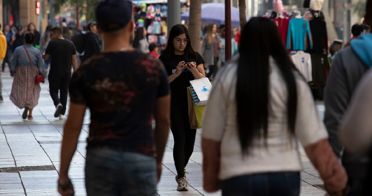 Personas comprando y transitando por un paseo peatonal