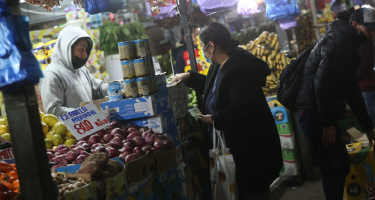 Mujer comprando frutas y verduras en un mercado