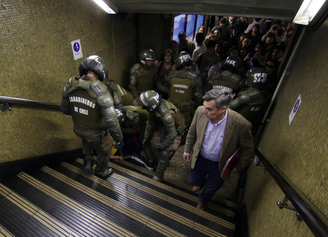 Carabinero deteniendo a estudiante en evasión del Metro durante el 18 de octubre del 2019 en el estallido social