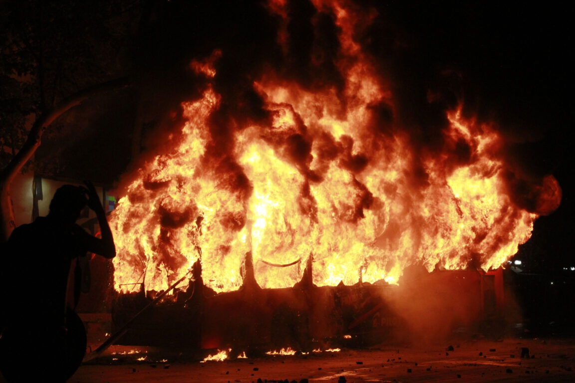 Bus RED (Transantiago) quemándose en la Plaza Baquedano durante el estallido social el 18 de octubre