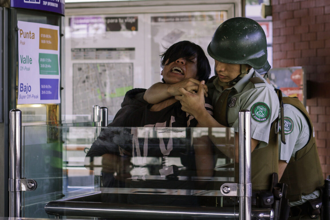 Carabinero deteniendo a estudiante en evasión del Metro durante el 18 de octubre del 2019 en el estallido social