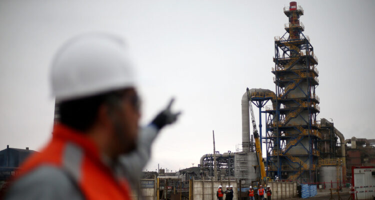 hombre con ropa de seguridad apuntando a la chimenea de la fundición hernán videla lira