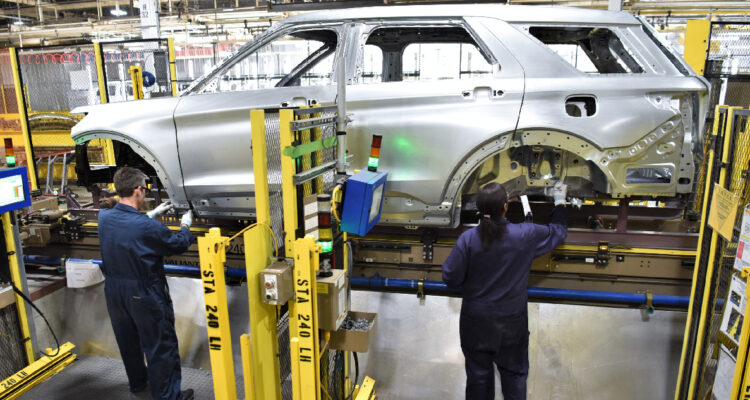 dos personas trabajando en una planta de producción de ford en Chicago, Estados Unidos