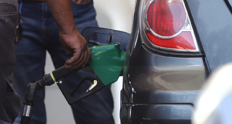 hombre usando un surtidor de combustible