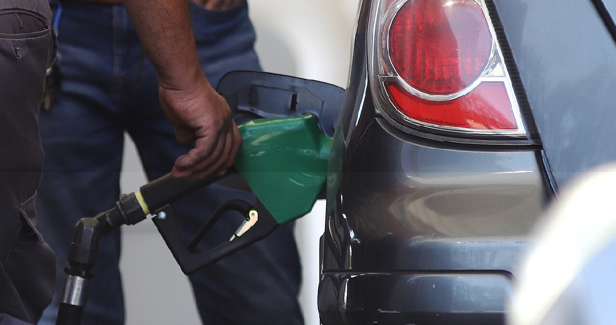 hombre usando un surtidor de combustible