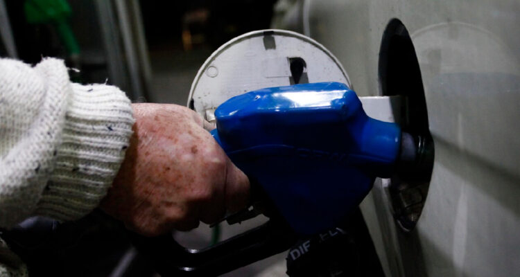 hombre echando combustible en un vehículo