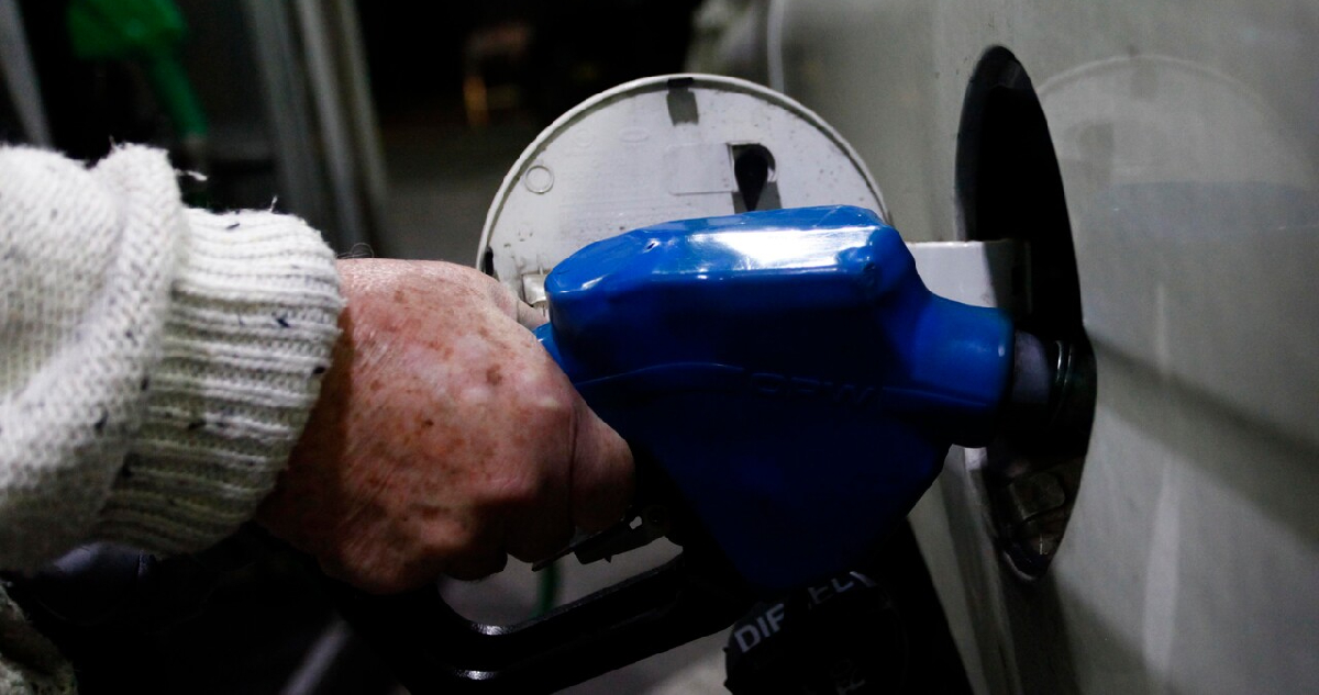 hombre echando combustible en un vehículo
