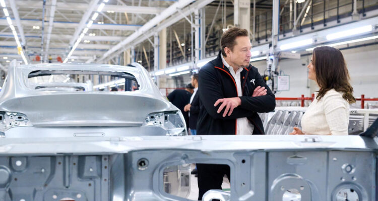 Elon Musk conversando con la presidenta de Hungría, Katalin Novak, en una fábrica de Tesla