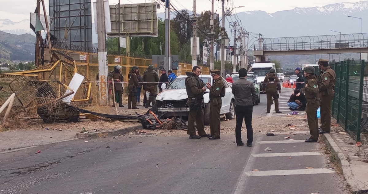 Carabineros rodean el sitio del suceso, en que automóvil baleado permanece en la caletera.