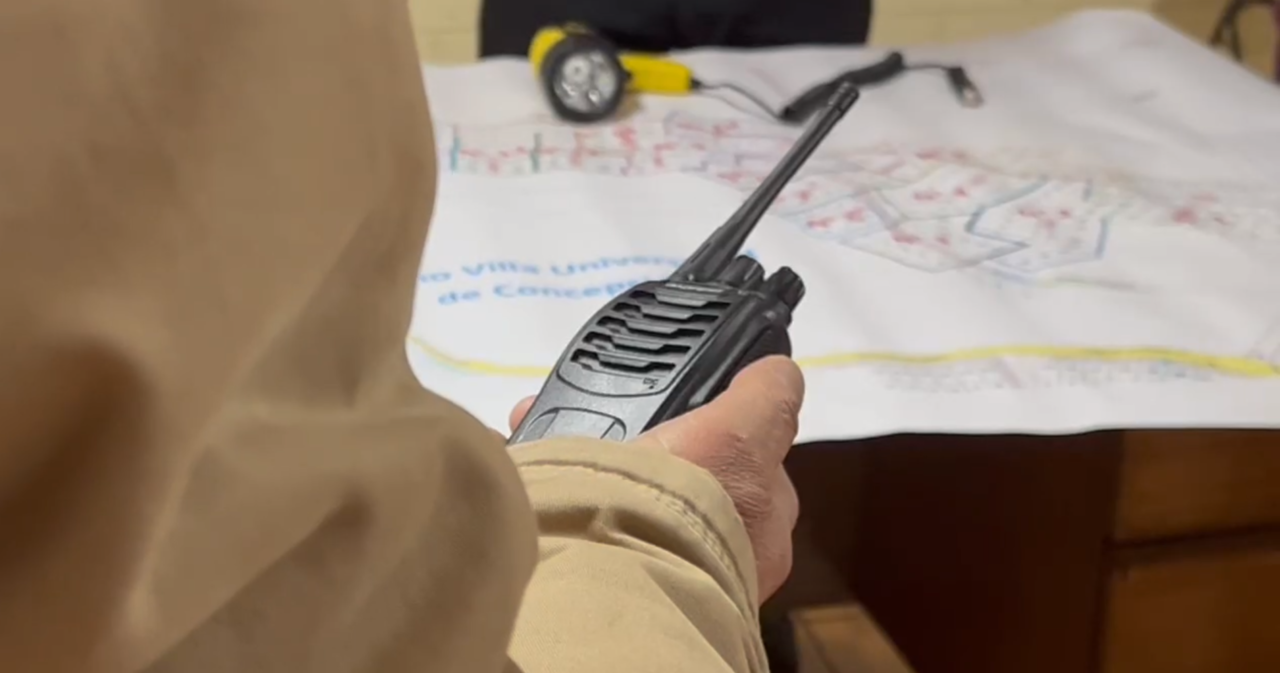 Vecino con un walkie talkie, preparándose para salir a patrullar en la Villa Universidad de Concepción.