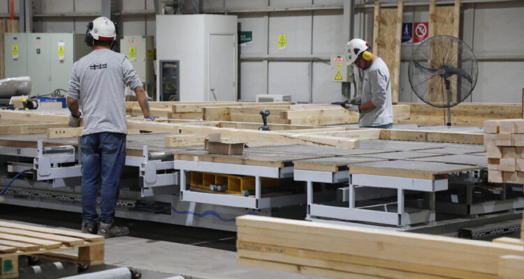 Personas trabajando en una fábrica de viviendas industrializadas
