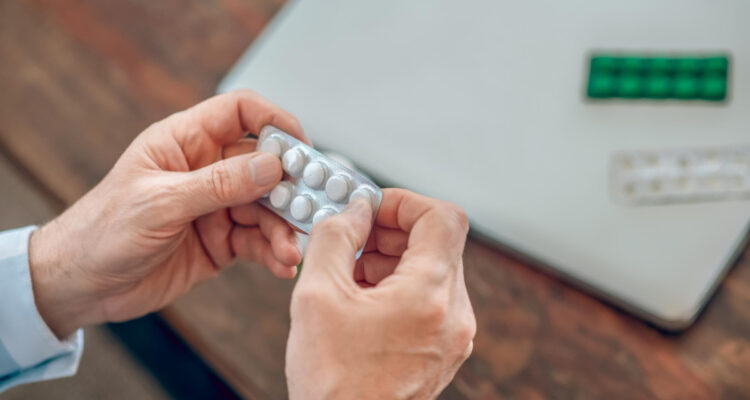 Dos manos sosteniendo blister de paracetamol o ibuprofeno.