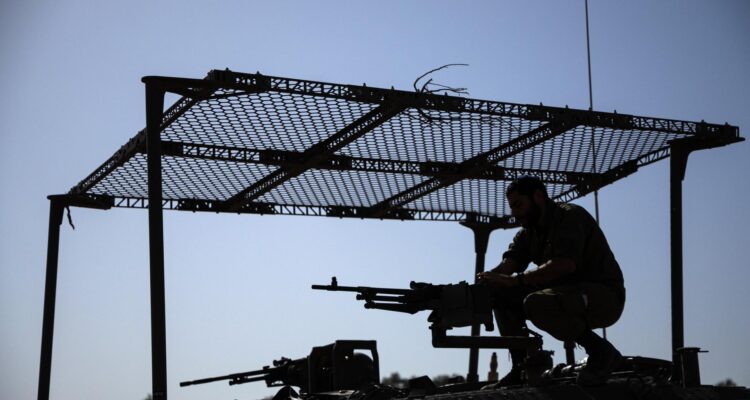 Un soldado israelí maneja una ametralladora encima de un vehículo blindado en la frontera con la Franja de Gaza.