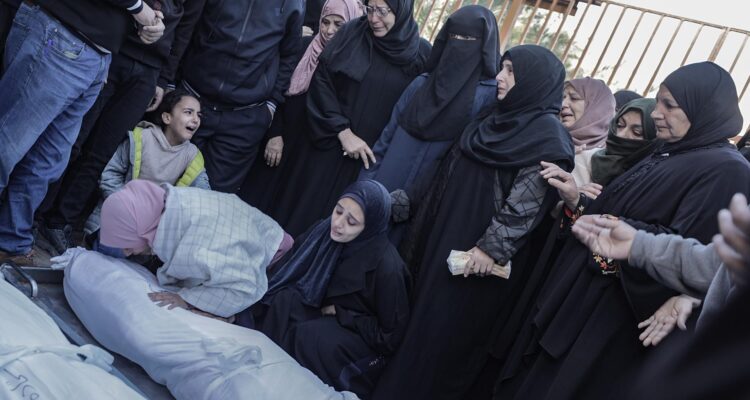 Familiares de palestinos que murieron tras los ataques aéreos israelíes contra un edificio al sur de Gaza