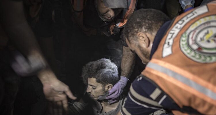 Un hombre es rescatado de los escombros de un edificio residencial tras un ataque israelí en Jan Yunis