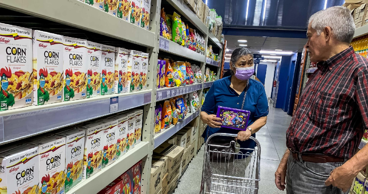 Dos personas observan cajas de cereales Kellogg's en un supermercado, el 20 de noviembre del 2023, en Caracas (Venezuela)