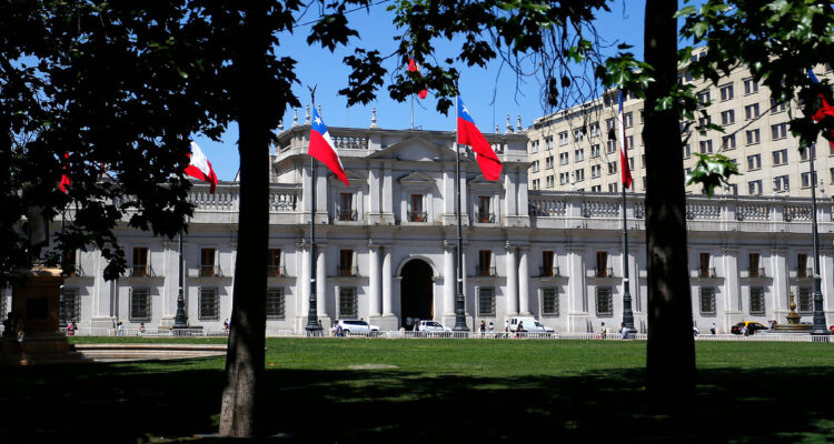 Fachada del palacio de la moneda en el plano fondo al frente, árboles de la plaza de la constitución