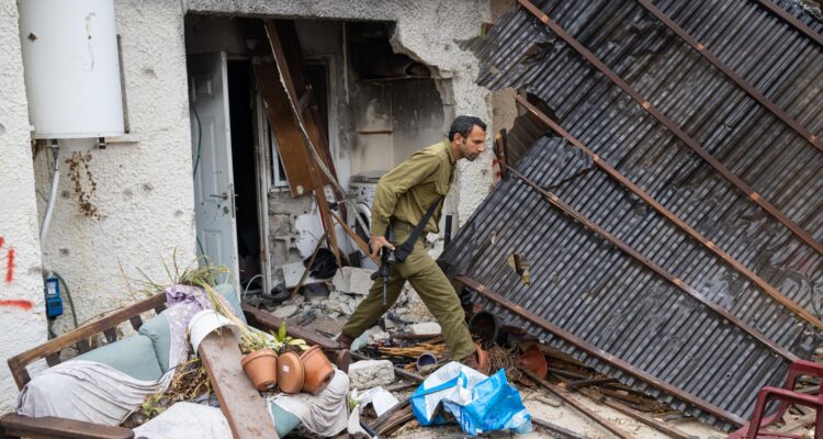 Un soldado israelí inspecciona una casa dañada en el kibutz Kfar Aza, al sur de Israel