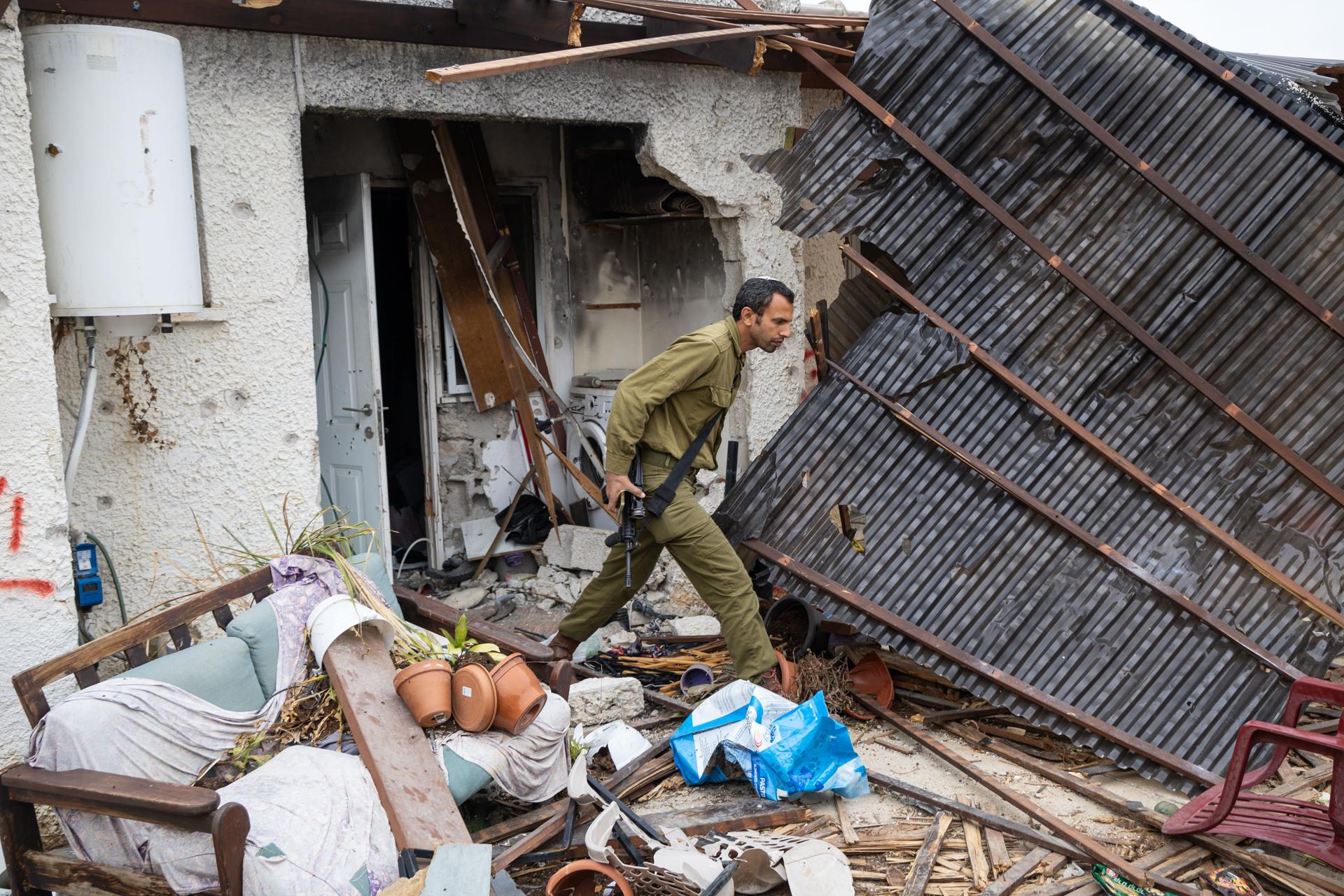 Un soldado israelí inspecciona una casa dañada en el kibutz Kfar Aza, al sur de Israel