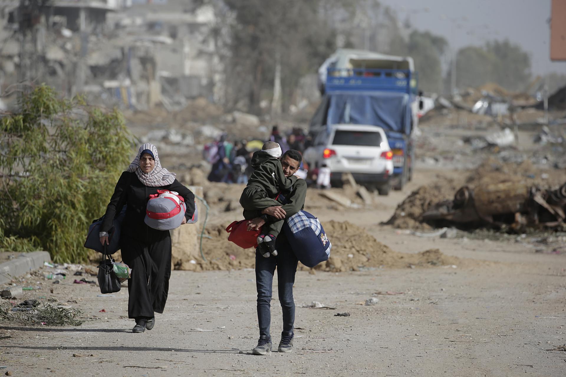 Los palestinos caminan después de cruzar del norte de la Franja de Gaza al sur de la Franja de Gaza.