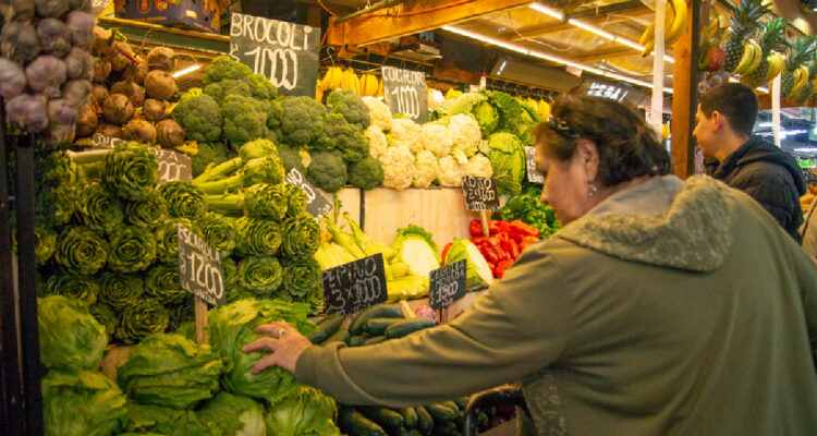 MUJER COMPRANDO VERDURAS EN LA FERIA