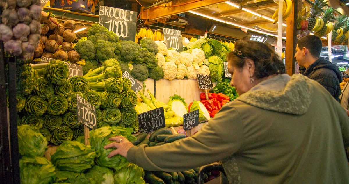 MUJER COMPRANDO VERDURAS EN LA FERIA