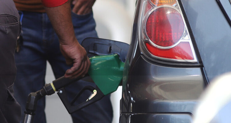 Hombre echando gasolina en un vehículo: detalle del surtidor