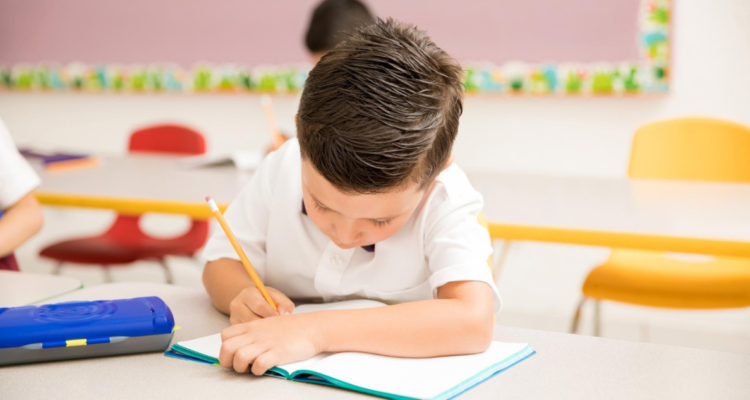 Niño escribiendo a mano en referencia a clases de letra caligrafía
