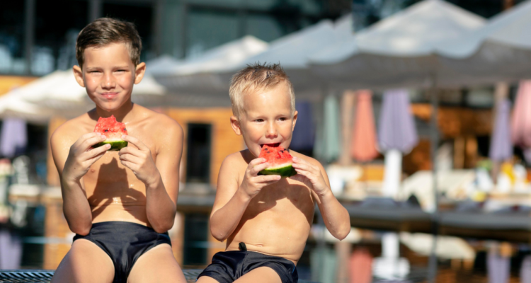 Niños comiendo a la orilla de una piscina en referencia a mitos del verano