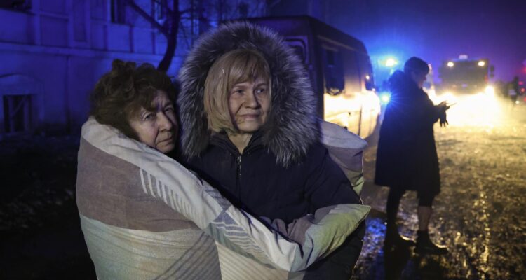 Residentes en el lugar de un ataque nocturno con cohetes rusos en Járkov
