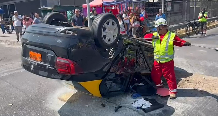 Taxi casi se incendia tras volcarse en Santiago: fue colisionado por conductor que no respetó luz roja