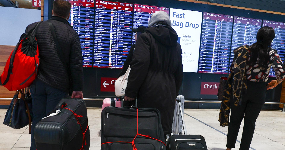 Pasajeros chequeando sus vuelos en el aeropuerto de Berlín-Brandeburgo, en medio de la huelga del personal de tierra de Lufthansa 
