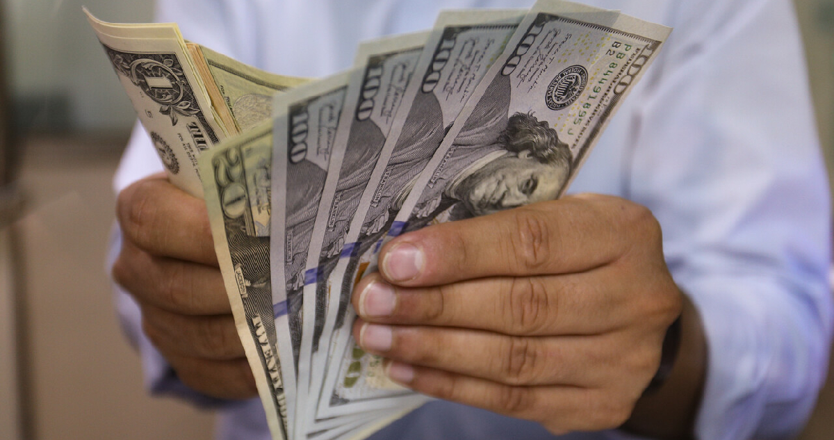 Hombre sostiene varios billetes