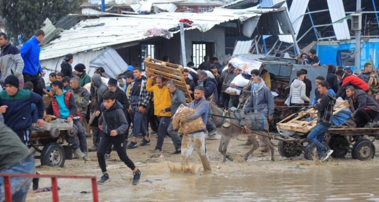 Palestinos con sacos de harina que tomaron de un camión de ayuda en Gaza el 27 de enero