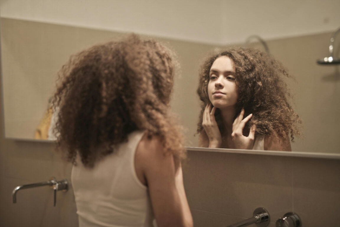 Mujer pensando frente al espejo