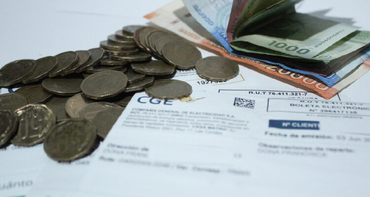 fotografía contexto de cuentas de luz, se aprecia una boleta, varias monedas y billetes