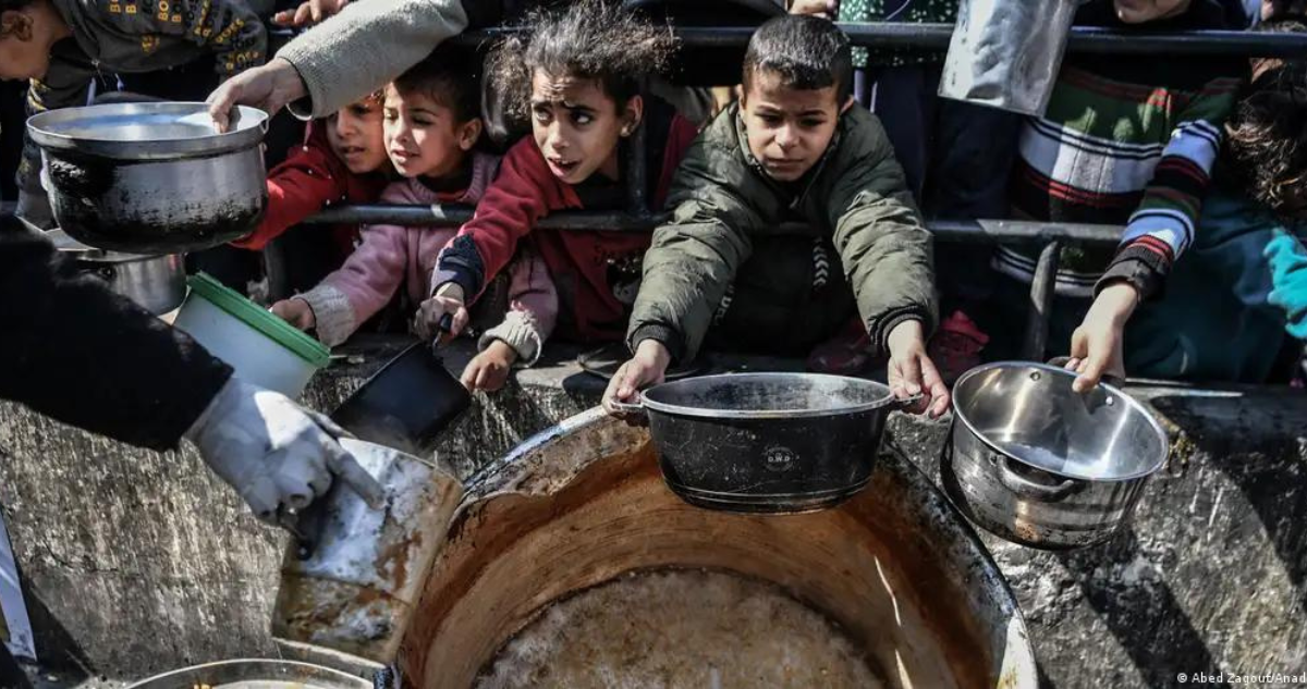 Niños palestinos esperan recibir comida distribuida por organizaciones de caridad gazatíes