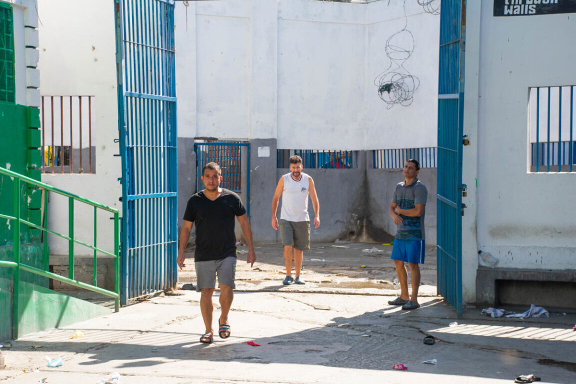 Colombianos vinculados al magnicidio del presidente de Haití Jovenel Moise en 2021 caminan en un patio de la Penitenciaria Nacional luego del ataque por parte de bandas armadas, este domingo en Puerto Príncipe (Haití). 