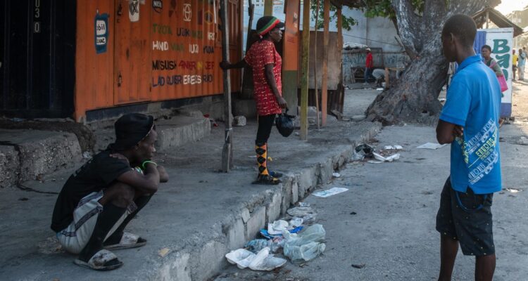 Personas esperan cerca a la Penitenciaría Nacional este domingo, en Puerto Príncipe (Haití). Al menos una decena de personas murió tras el ataque anoche a la prisión civil de Puerto Príncipe por parte de bandas armadas, que habrían liberado a numerosos delincuentes importantes durante su asalto al presidio.