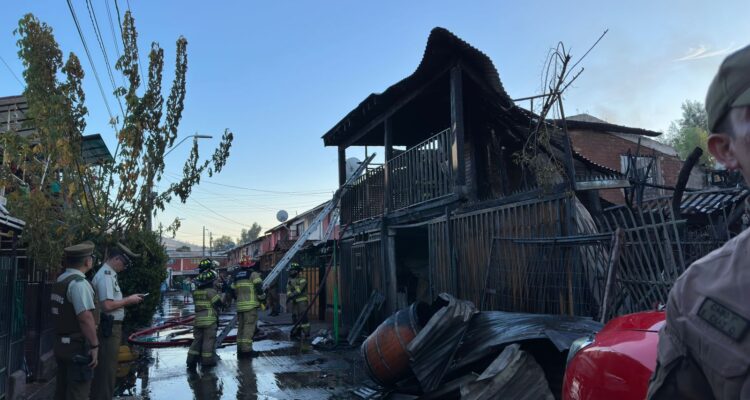 Bomberos trabajando en el lugar del incendio en que fallecieron dos adultos mayores en Renca.