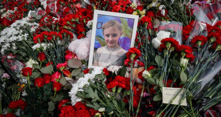 La foto de un niño entre las flores en la sala de conciertos Crocus City Hall