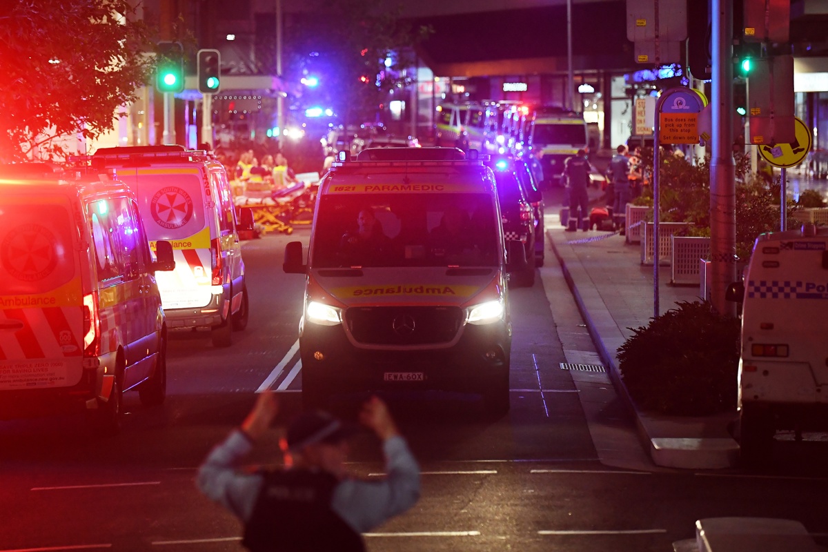 Sydney (Australia), 13/04/2024.- A police officer directs an ambulance after police responded to reports of multiple stabbings inside the Westfield Bondi Junction shopping centre in Sydney, Australia, 13 April 2024. New South Wales Police confirmed that at least six people died following a knife attack carried out by a man who was later shot dead by police. Several others were hospitalized with some in critical conditions.