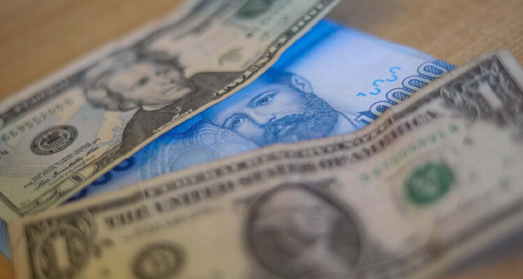 billetes de dólar y de peso chileno