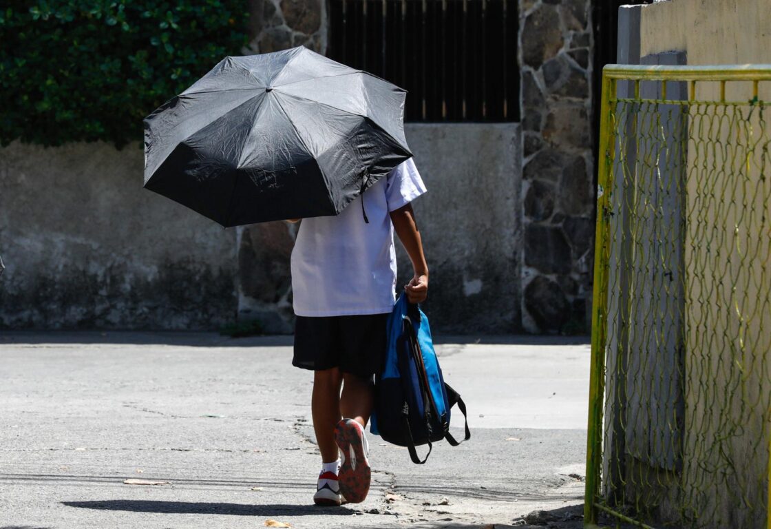 Un estudiante de sexto grado usa un paraguas en Calumpit, provincia de Bulacán, Filipinas